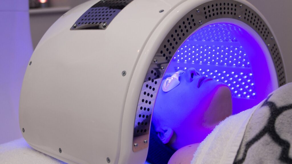 A woman inside a Dermalux LED Phototherapy machine.