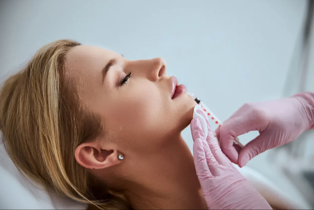 A woman is to be injected during the botox and dermal fillers treatment.